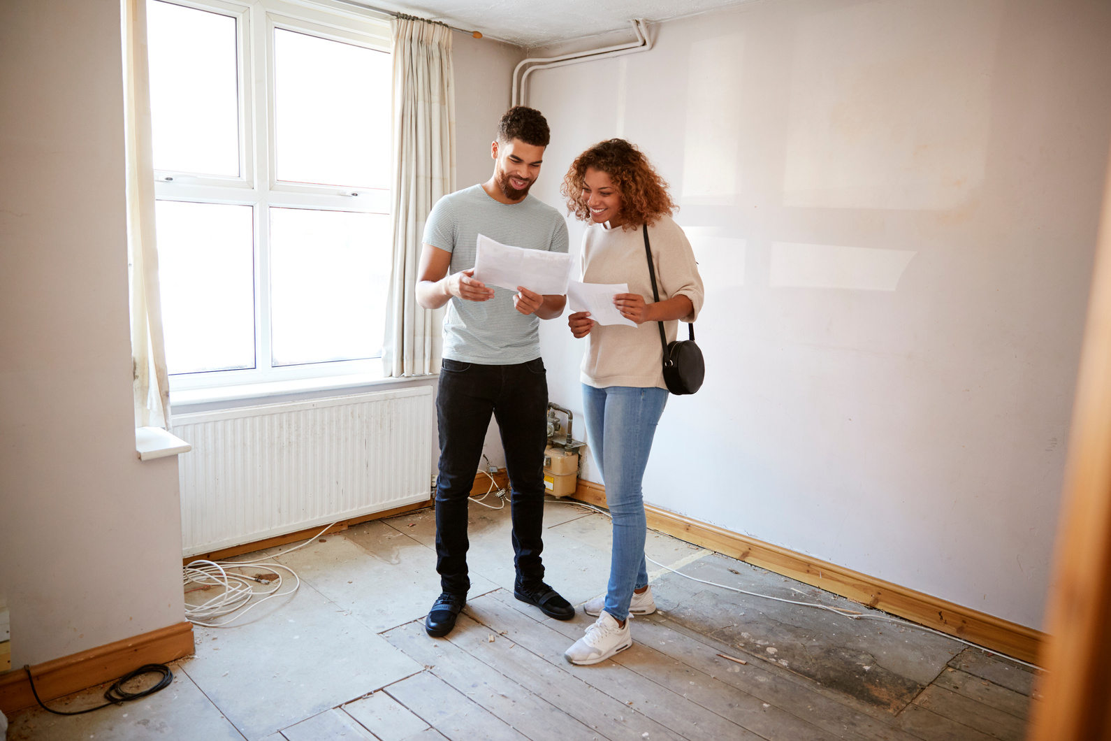 Couple Buying House for First Time Looking at House Survey in Ro